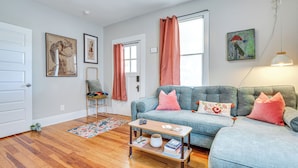 A living room with a blue sofa, a coffee table, and a rug. - 3 Mi to Downtown Covington: Cozy Getaway w/ Porch! (Porterdale)