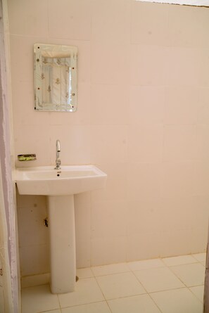 A bathroom with a white sink, a mirror, and a tiled floor. - Hinduja Camp Jaisalmer (Jaisalmer)