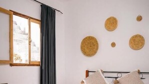A bedroom with a bed, bedside tables, a window, and woven wall decorations. - Soul Surf House (Agadir)