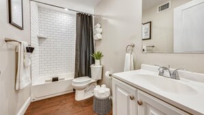 A modern bathroom with a white bathtub, toilet, and sink. - Clean contemporary escape (Boston)