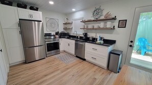 A modern kitchen with stainless steel appliances, white cabinetry, and wooden flooring. - "Sweet Reward"-*Labor Day Special!* Location X3! Pet Friendly! (Gulf Shores)