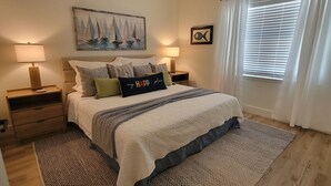 A neatly arranged bedroom with a bed, two bedside tables, a nightstand, a rug, and a painting on the wall. - "Sweet Reward"-*Labor Day Special!* Location X3! Pet Friendly! (Gulf Shores)