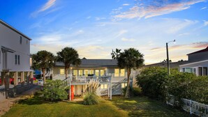 A two-story house with a covered porch, a small garden, and a street view. - Inlet Front Beach House 4BR 4BA Pet Friendly Private Dock (Garden City Beach)