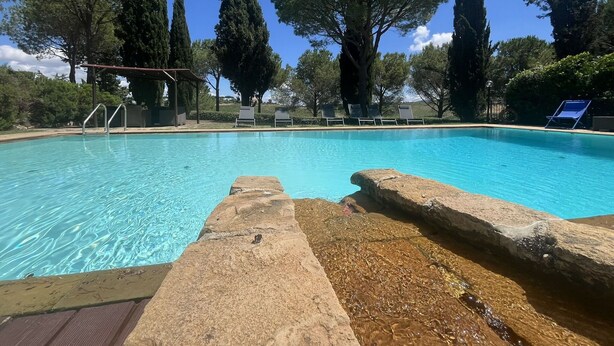 A clear swimming pool with lounge chairs and a pergola. - Villa with Pool and Gym (Diaccialone)