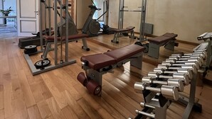 A gym with various exercise equipment, including treadmills, weight machines, and dumbbells. - Villa with Pool and Gym (Diaccialone)