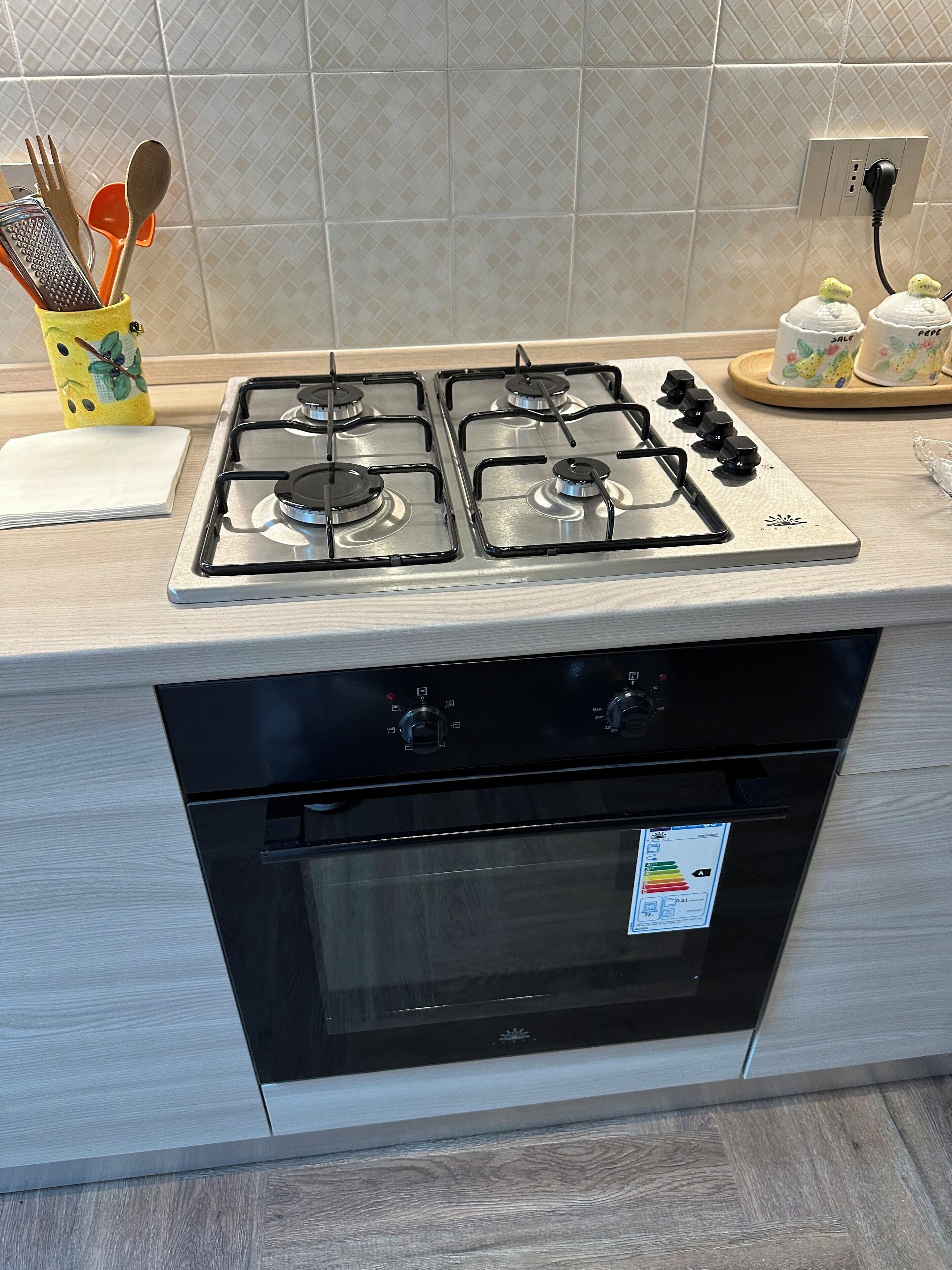 A kitchen with a gas stove, oven, and a tiled backsplash.