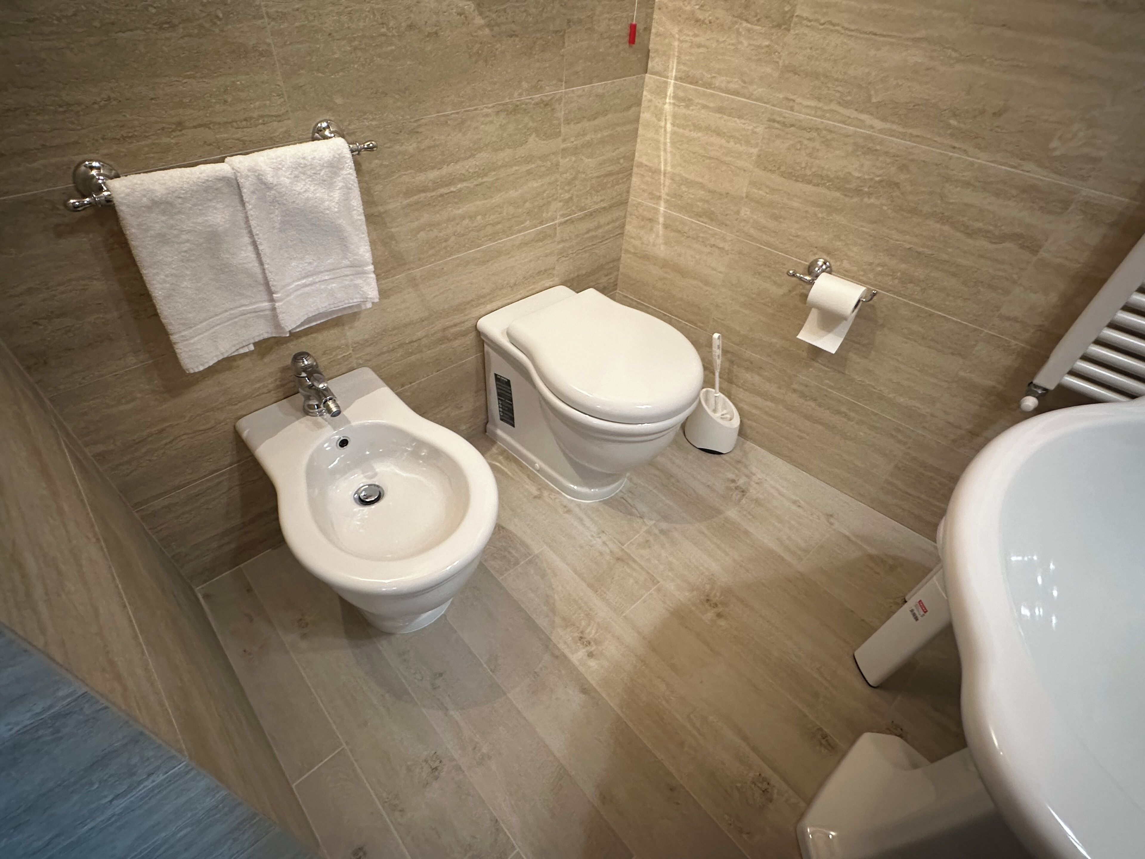 A modern bathroom with a bidet, toilet, and sink.
