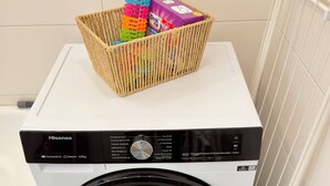 Eine Hisense Waschmaschine mit Frontlader und einem Wäschekorb mit Waschmittel darauf.