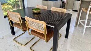 Une cuisine moderne avec une table à manger, des chaises et une machine à café.