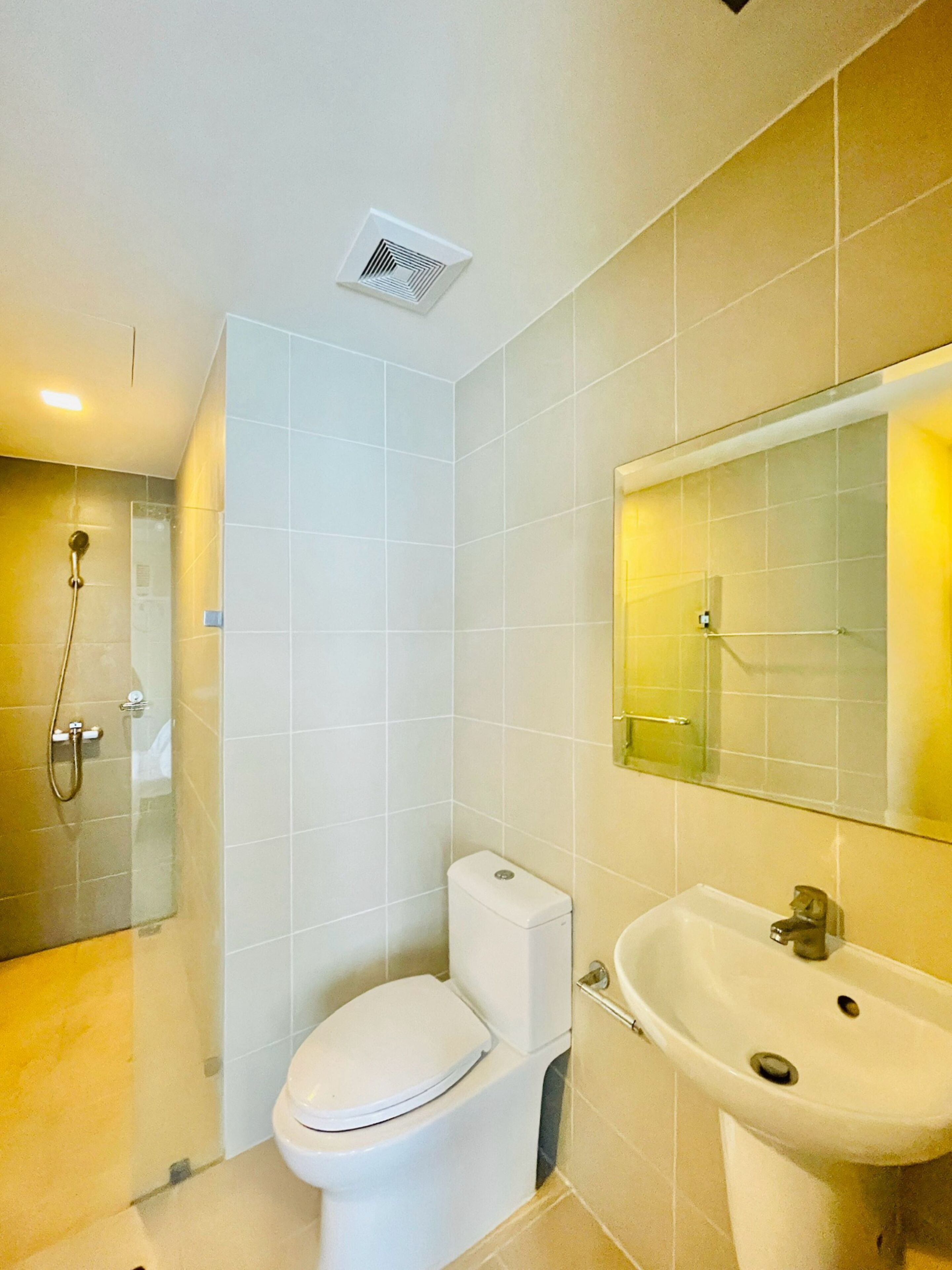 A bathroom with a toilet, sink, and shower.