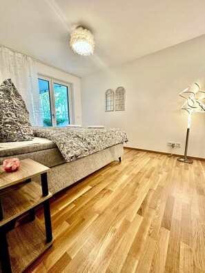 En moderne stue med sofa, et lille bord og en gulvlampe.