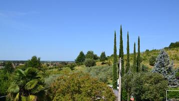 A residential area with a view of a hill, trees, and a clear sky.