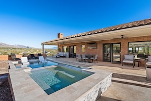 Una propiedad residencial con piscina, mobiliario exterior y vistas a las montañas.