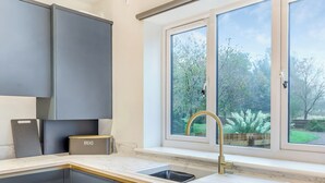 A kitchen with a window, a sink, and cabinets. - The Bunker - UK47763 (Bamburgh)
