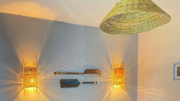 A bedroom with a bed, two nightstands, a wooden headboard, and wall-mounted lighting fixtures. - Pousada Américas (Guarujá)