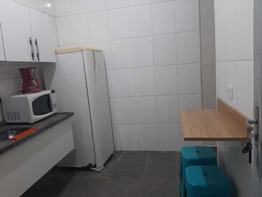 Chalet | Privékeuken | Een microgolfoven, een oven, een kookplaat, kookgerei, borden en bestek