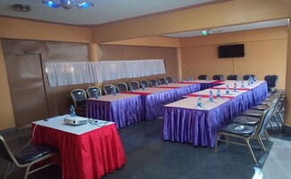 A conference room with long tables, chairs, and a projector.