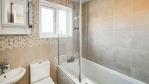 Ein Badezimmer mit Toilette, Waschbecken und Duschbereich.