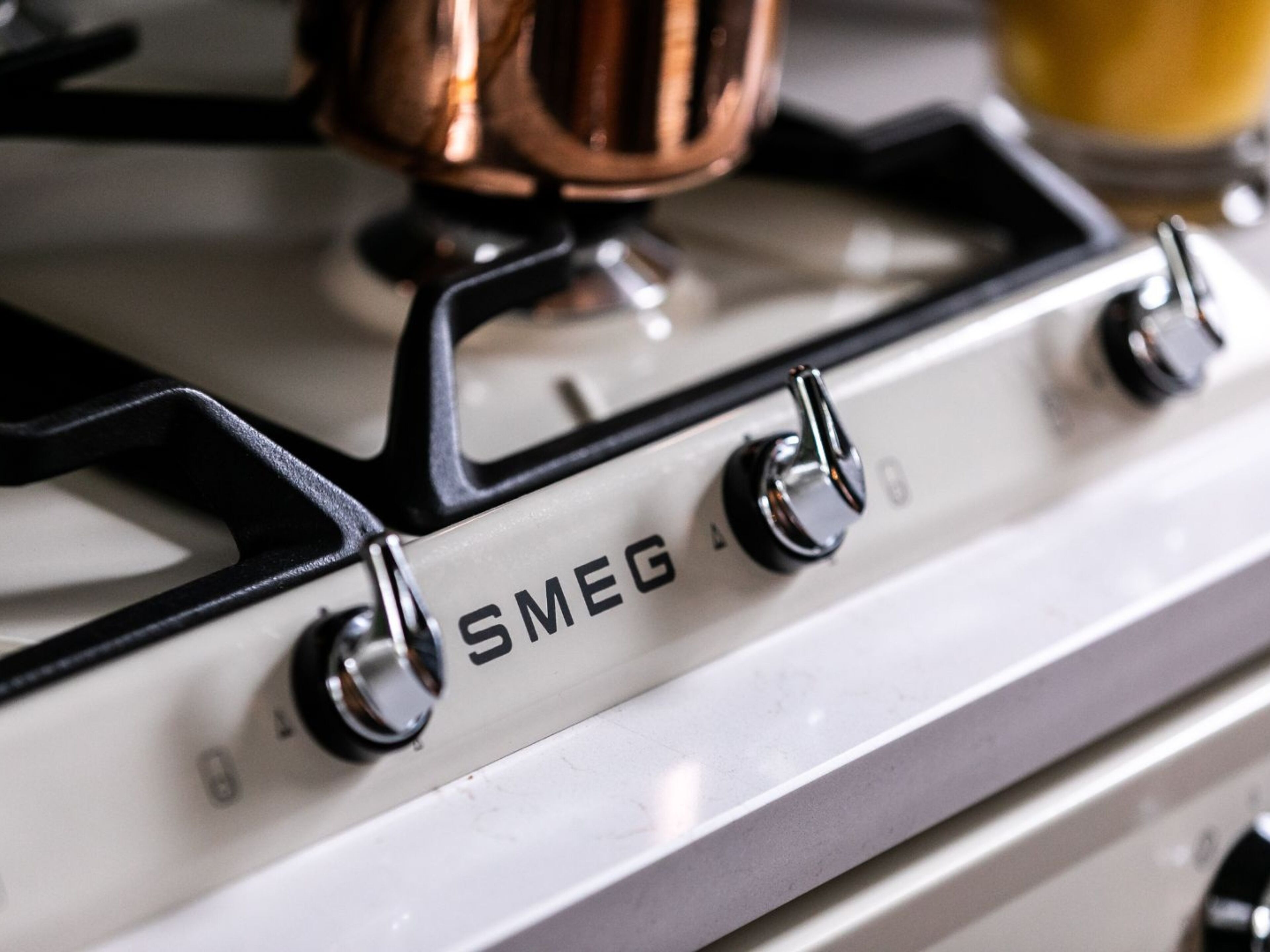 A white stove with four knobs and the brand name "SMEG" visible on the front.