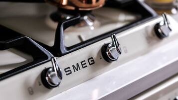 A white stove with four knobs and the brand name "SMEG" visible on the front.