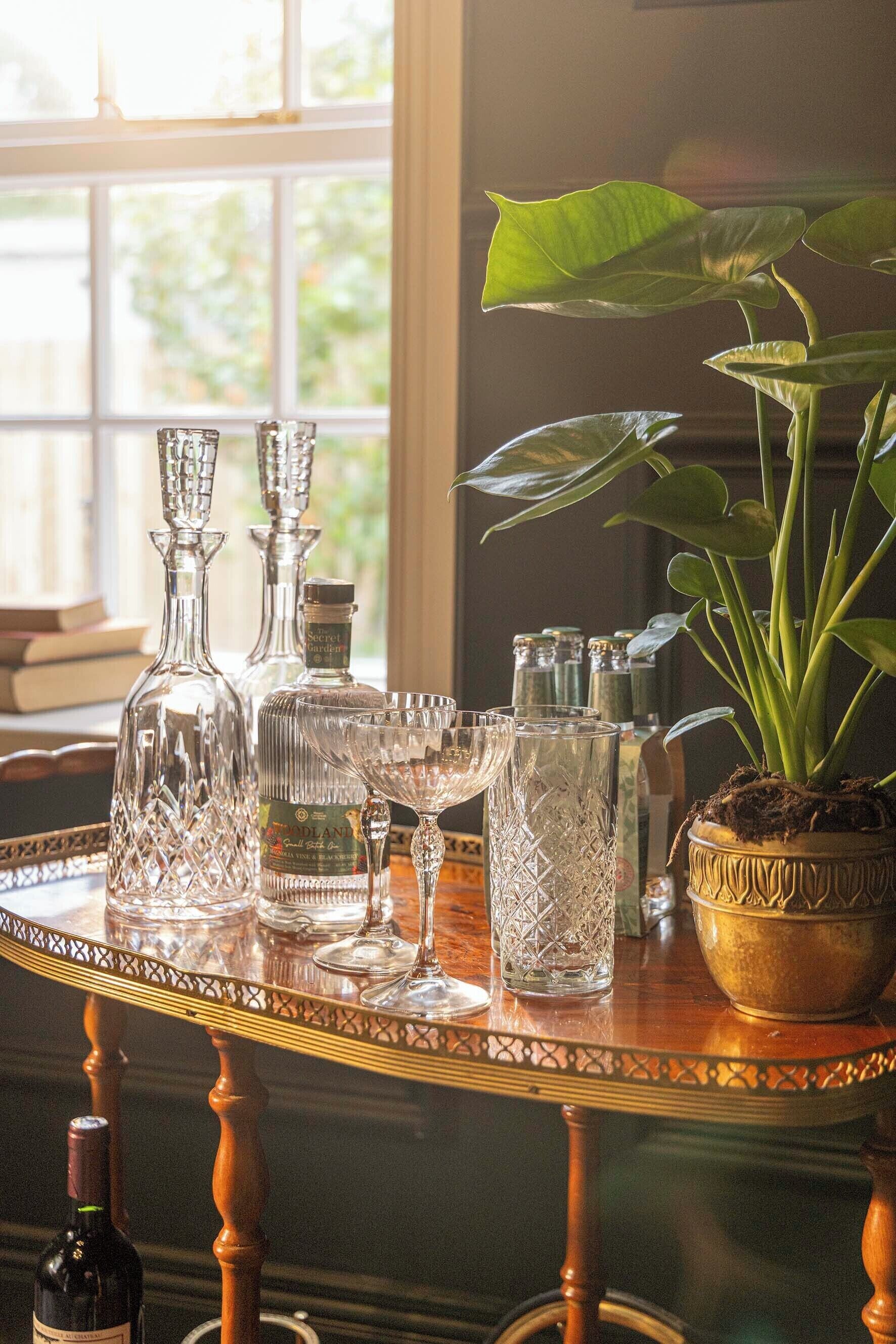 A table with glassware and a potted plant.