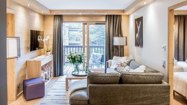A modern living room with a sofa, a coffee table, and a balcony with a view. - Wifi, 150m from resort center, 3rd floor, sauna, balcony, parking, tv, 64m², Courchevel (Courchevel)