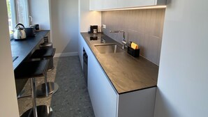 Une cuisine moderne dotée d’un long plan de travail, de meubles de rangement intégrés et d’une fenêtre laissant entrer la lumière naturelle.