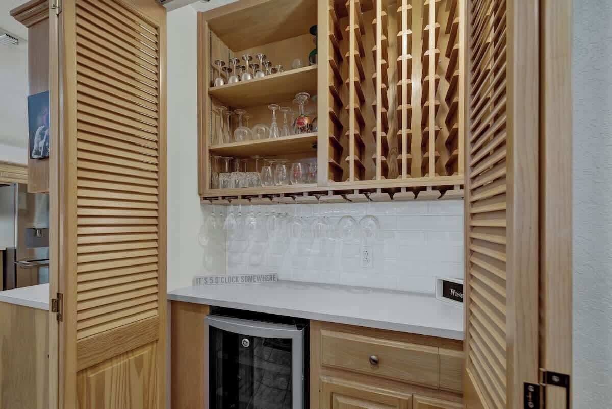 A kitchen with wooden cabinets, a wine rack, and a built-in refrigerator.