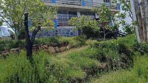 A building with multiple balconies and a stone wall in the foreground. - Dede Sebo Camping (Dogubayazit)