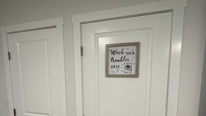 Two white doors with a framed sign above the right door.