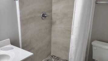 Habitación estándar, 1 cama King size | Baño | Regadera, toallas, jabón, shampoo