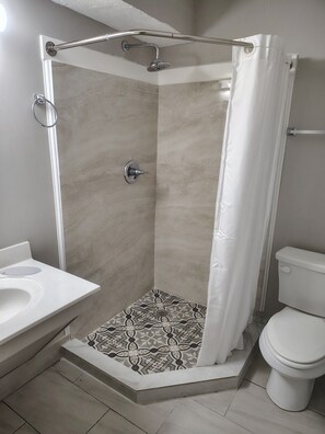 Habitación estándar, 1 cama King size | Baño | Regadera, toallas, jabón, shampoo 