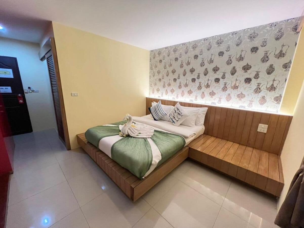 A modern bedroom with a wooden bed, a bedside bench, and a patterned wallpaper.