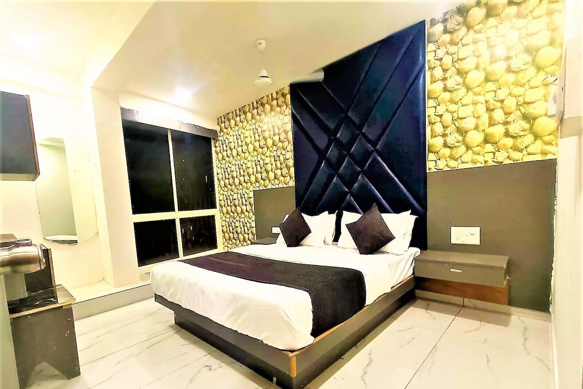 A modern bedroom with a large bed, a built-in wardrobe, and a stone wall.