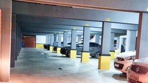 A multi-level parking garage with clearly marked parking spaces and a drainage grate on the floor. - Beachfront Apartment, Prime Location (Centro Cabo Frio)