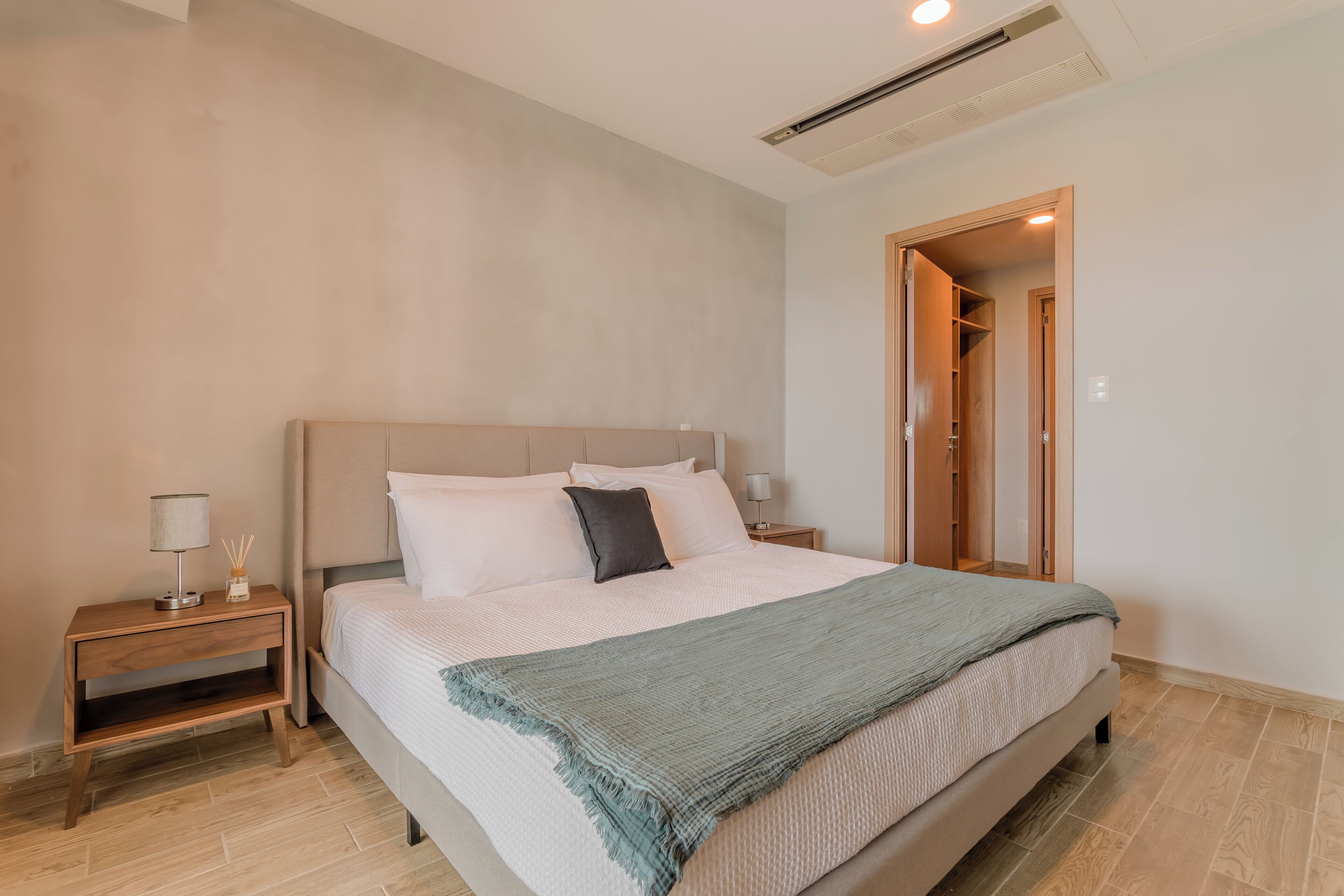 A bedroom with a bed, nightstands, a bedside table, and a wardrobe.