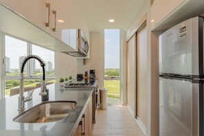 Departamento Confort, vista al campo de golf | Cocina privada | Refrigerador con congelador, microondas, horno y parrilla de estufa