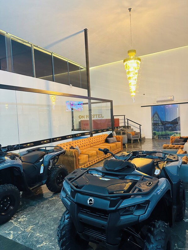 A modern interior with a large sofa, multiple ATVs, and a sign reading "ON HOSTEL". - On Hotel campos do Jordao centro Capivari e passeio quadriciclo (Campos do Jordão)