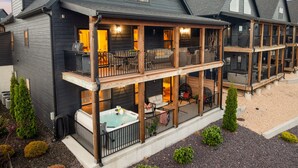 A two-story building with a balcony, outdoor seating, and a hot tub. - Solid Rock Lodge >Lake View >Hot Tub >Indoor Pool > Near Big Cedar&Thunder Ridge (Hollister)