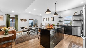 A modern kitchen with a central island, black cabinetry, stainless steel appliances, and pendant lighting. - Solid Rock Lodge >Lake View >Hot Tub >Indoor Pool > Near Big Cedar&Thunder Ridge (Hollister)
