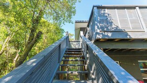 Eine Holztreppe führt zu einem Gebäude mit weißer Fassade.