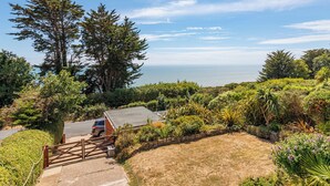 A coastal property with a paved driveway leading to a vehicle, surrounded by dense greenery and overlooking the sea. - 1 bedroom accommodation in Ventnor (Ventnor)