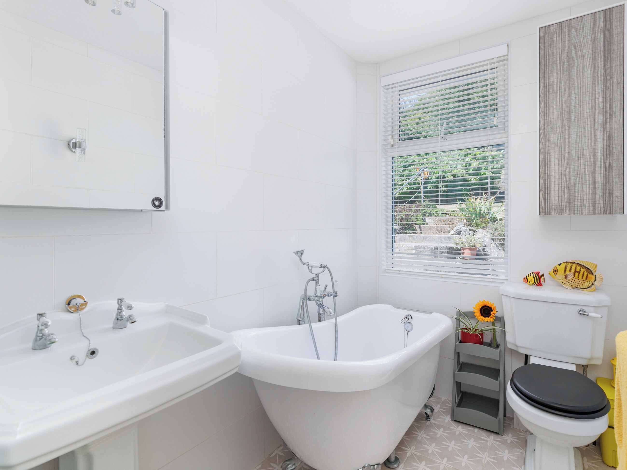 A bathroom with a white sink, a freestanding bathtub, and a toilet.