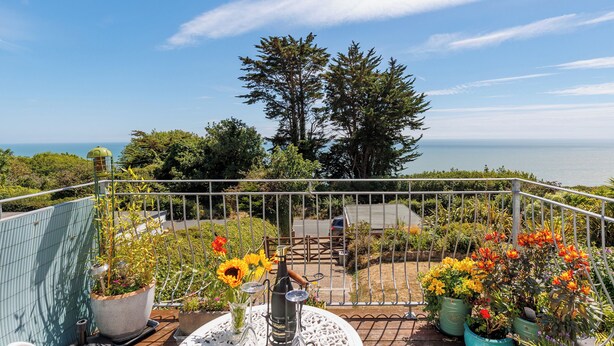 A balcony with a view of the ocean, potted plants, and outdoor furniture. - 1 bedroom accommodation in Ventnor (Ventnor)