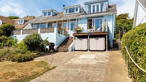 A two-story house with a balcony, a garage, and a garden area. - 1 bedroom accommodation in Ventnor (Ventnor)