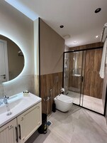Vierpersoonskamer, uitzicht op stad | Badkamer | Een douche, een haardroger, pantoffels, handdoeken