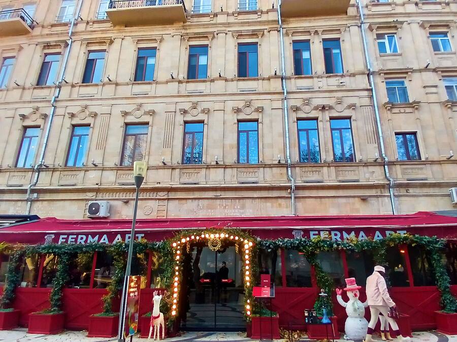 En byggnad med ett rött markis och en skylt med texten "FERMA ART".