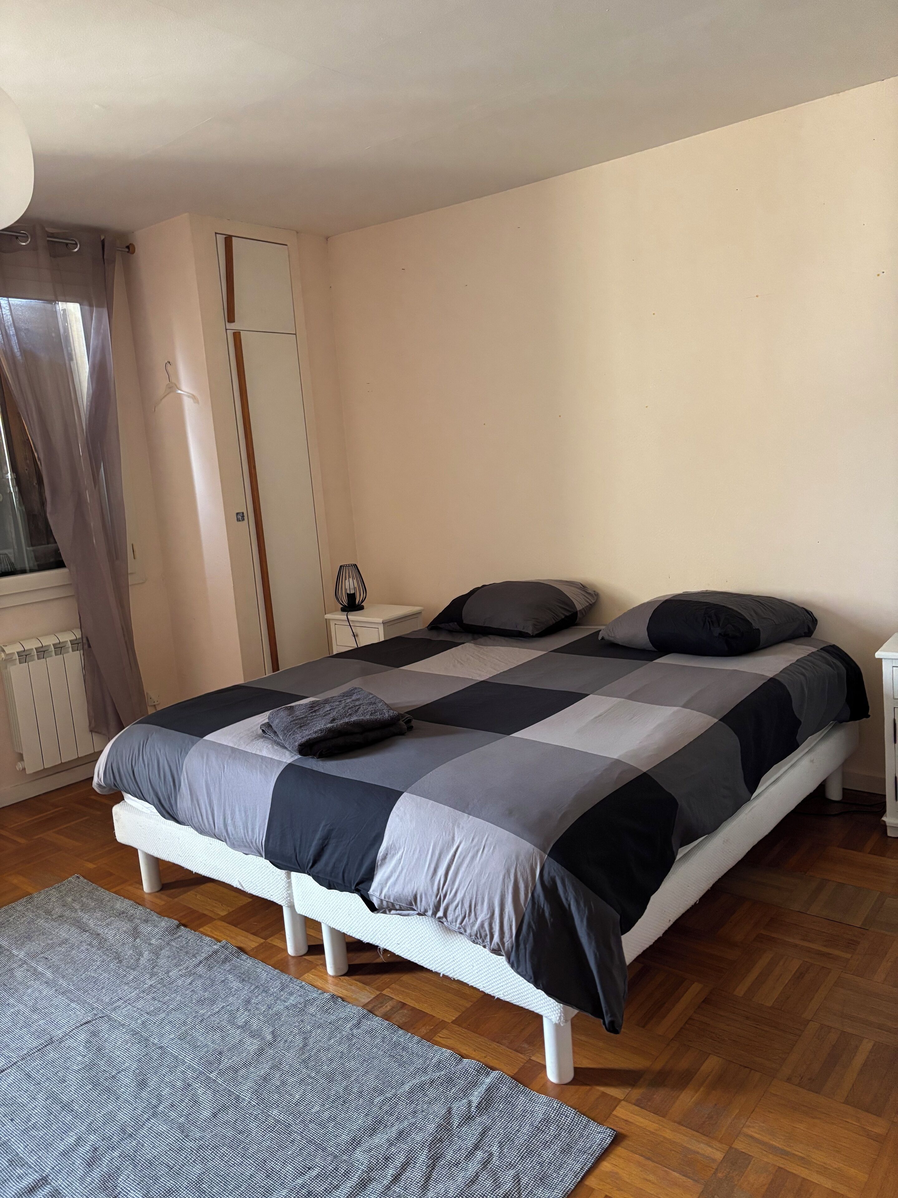Una camera da letto con un letto, un comodino, un armadio e un termosifone.