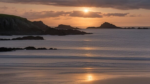 A coastal sunset with rocky outcrops and calm sea. - Awelfa: Modern 3-Bed Home in Rhosneigr | Managed by Anglesey Holiday Lettings (Rhosneigr)