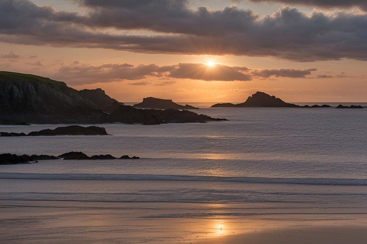A coastal landscape with a sunset over the sea, rocky outcrops, and a clear sky.